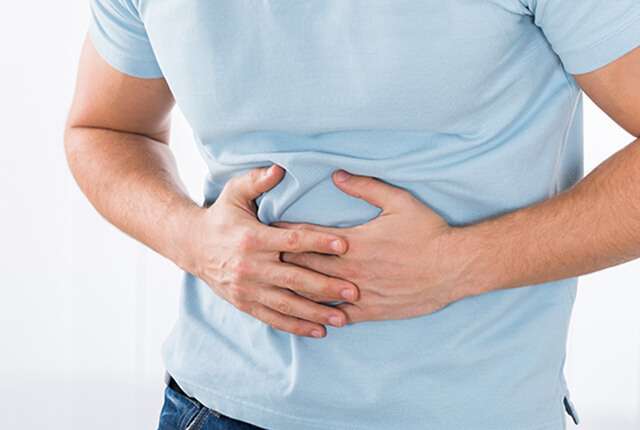 お腹を押さえている男性
